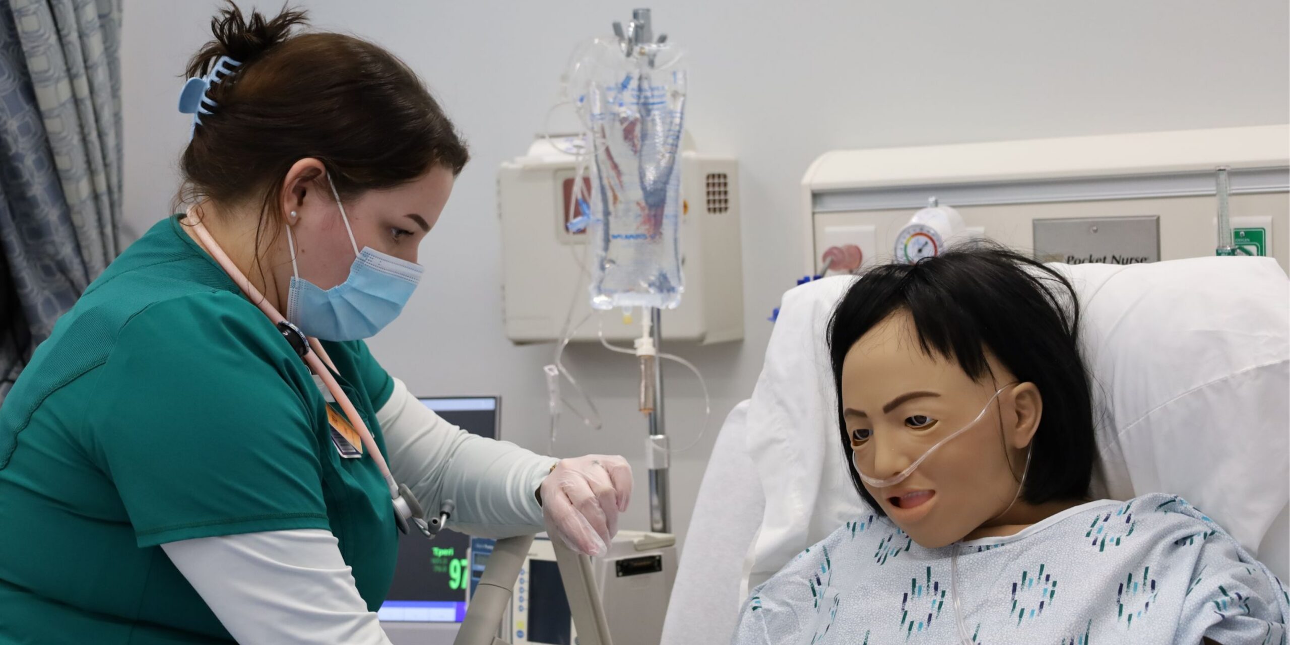nursing student checking vitals on simulation doll
