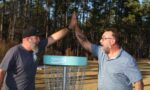 two disc golf players sharing a high five at BCC