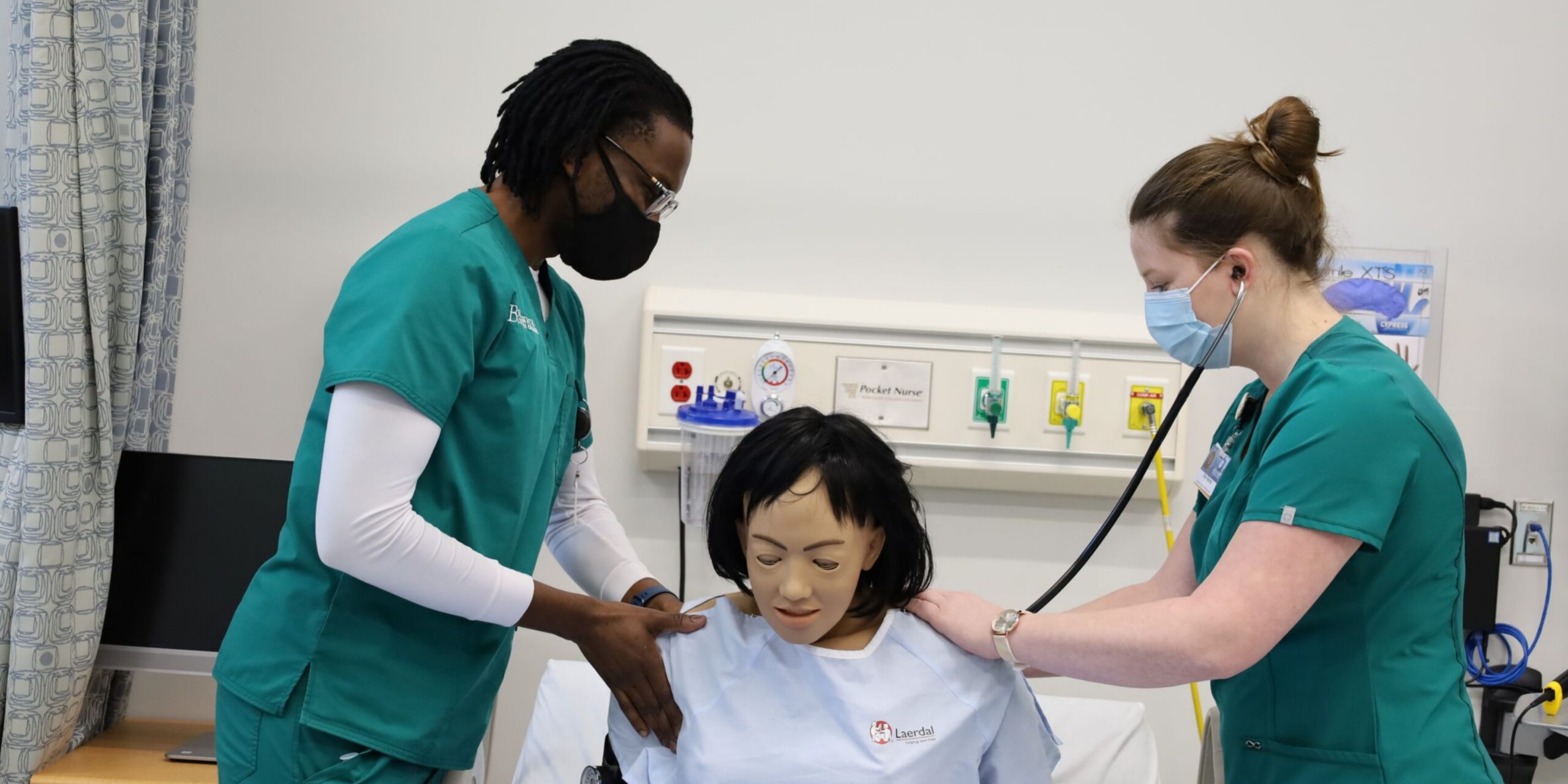 TWO NURSING STUDENTS WITH SIM DOLL